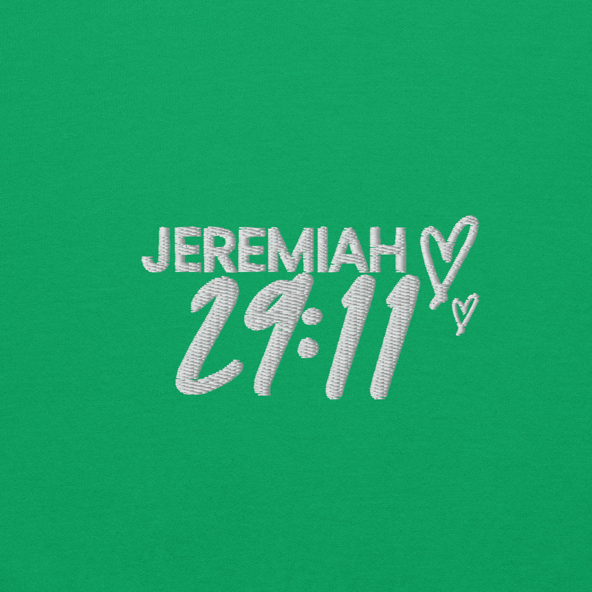 Zoomed in view of text Jeremiah 29.11 embroidery in white on a green sweater