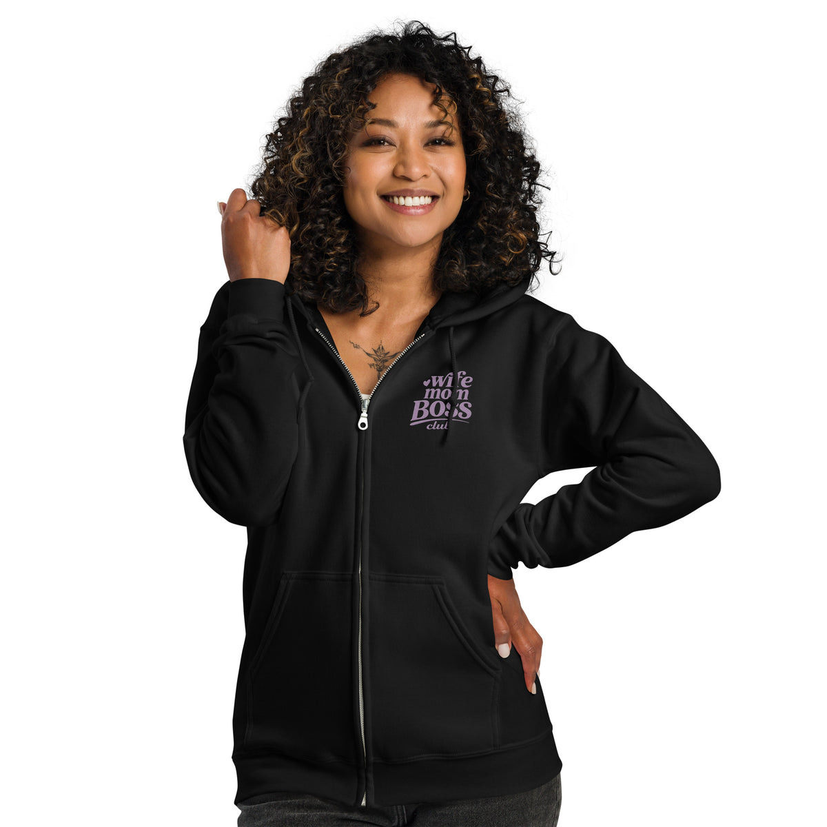 Woman wearing a black hoodie with 'Wife Mom Boss Club' embroidered  text in lavender on a white background